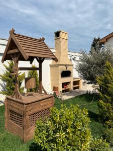 een houten prieel in een tuin met een pizzaoven bij Family villa in Baku