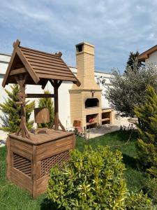 Un cenador de madera en un patio con un horno de pizza. en Family villa, en Baku