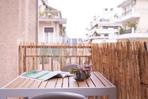- une table avec un livre et des fleurs sur un balcon dans l'établissement Cozy Studio at Ampelokipi Area, à Athènes