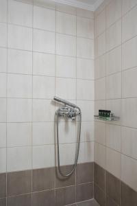 La salle de bains est pourvue d'une douche et de carrelage blanc. dans l'établissement Cozy Studio at Ampelokipi Area, à Athènes