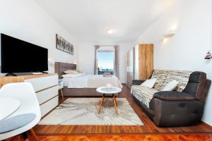 a bedroom with a bed and a tv and a couch at Apartments & Room Anita in Rovinj