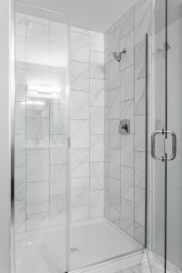 a shower with a glass door in a bathroom at Downtown Vine St Studio at The Guild in Cincinnati