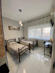 1 Schlafzimmer mit 2 Betten, einem Tisch und einem Fenster in der Unterkunft B&B I Girasoli in San Donato Milanese