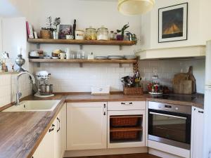 a kitchen with white cabinets and a sink at Charming House Ruža in Korčula Town in Korčula