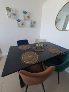 a black dining room table with chairs and a mirror at Casa de descanso in Caldera