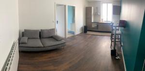 a living room with a couch and a kitchen at Appartement 5 chambres tous conforts - WIFI - TV in Saint-Étienne