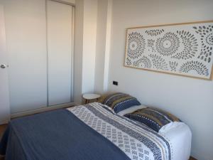 a bedroom with a bed and a picture on the wall at Appart Cosy T3 (Vue Mer et Piscine 4-5 pers) in Blanes