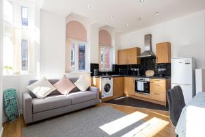 a living room with a couch and a kitchen at Central Liverpool L1 in Liverpool