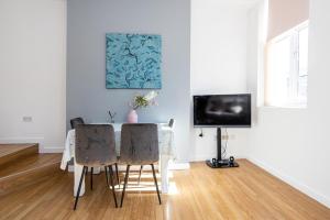 a dining room with a table and a television at Central Liverpool L1 in Liverpool