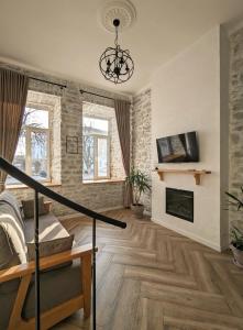 ein Wohnzimmer mit einem Kamin und einem Kronleuchter in der Unterkunft Квітка на камені , Старе місто, з окремим двориком in Kamjanez-Podilskyj