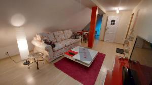 salon z kanapą i stołem w obiekcie Apartamenty Stokrotka w mieście Lądek-Zdrój