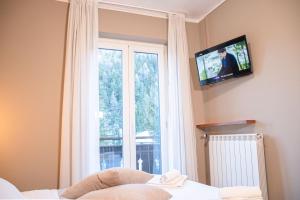 a bedroom with a window and a tv on the wall at Hotel La Betulla in Bardonecchia