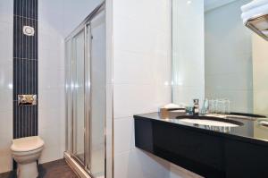 a bathroom with a toilet and a sink and a shower at Skeffington Arms Hotel in Galway