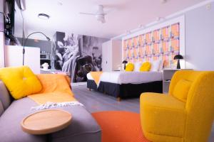 um quarto com uma cama, um sofá e uma cadeira em Fashion Boutique Hotel em Miami Beach