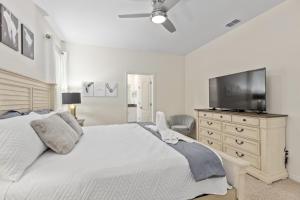 Dormitorio con cama y tocador con TV en 7579 Solterra by Orlando Holiday Rental Homes, en Loughman
