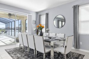 comedor con mesa, sillas y espejo en 7579 Solterra by Orlando Holiday Rental Homes, en Loughman