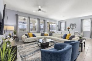 sala de estar con sofá blanco y sillas azules en 7579 Solterra by Orlando Holiday Rental Homes, en Loughman