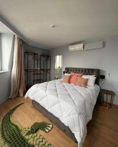 - une chambre avec un grand lit et un serpent vert au sol dans l'établissement Hôtel La Pièce, à Bruxelles