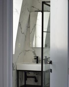 a bathroom with a sink and a mirror at Hôtel La Pièce in Brussels