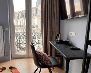 Cette chambre dispose d'un bureau et d'une chaise en face d'une fenêtre. dans l'établissement Hôtel La Pièce, à Bruxelles