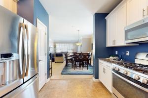 a kitchen with white cabinets and blue walls at Grande at Canal Pointe - 37696 Ulster Dr, Unit #12 in Rehoboth Beach