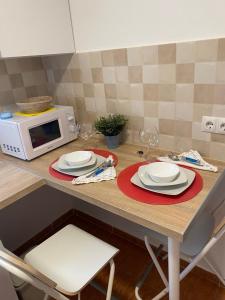 a kitchen counter with a table with plates and a microwave at Habitaciones con baño y cocina privada in Valencia