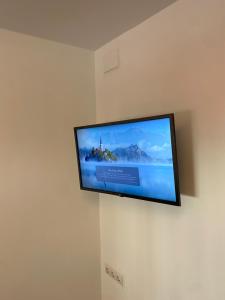 a flat screen tv hanging on a wall at Habitaciones con baño y cocina privada in Valencia