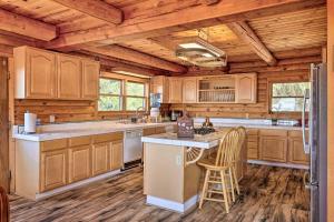 a kitchen with wooden cabinets and a kitchen island with chairs at Mountain Bliss Chalet with Great Views! in Sonora