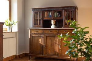 un meuble en bois avec un ours en peluche assis au-dessus dans l'établissement Schöne Wohnung am Stadtrand von Meran Valentinhof, à Merano