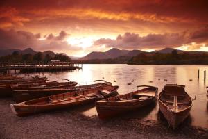 a group of boats sitting on the shore of a lake at The Kings Arms Hotel in Keswick