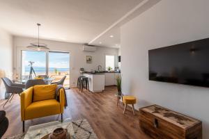 uma sala de estar com uma cadeira amarela e uma mesa em Magnifique appartement vue mer, spacieux et traversant em Ajaccio