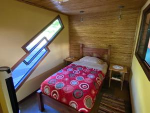 a bedroom with a red bed with a window at Indigo Container House in San Luis