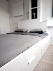 Una cama blanca en un dormitorio blanco con un cajón blanco en Nice and Sweet Apartment - self check in, en Zagreb