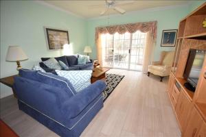 a living room with a blue couch and a television at 613 River Crossing Condo in North Myrtle Beach