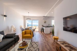 a living room with a couch and a table and a kitchen at Magnifique appartement vue mer, spacieux et traversant in Ajaccio