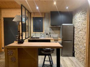 kuchnia z drewnianym blatem i lodówką w obiekcie Appartement de montagne cosy w mieście Angoustrine