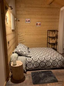 sypialnia z łóżkiem i drewnianą ścianą w obiekcie Appartement de montagne cosy w mieście Angoustrine