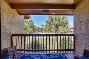 een balkon met uitzicht op een zwembad en palmbomen bij Sun-Dappled PCB Retreat with Multiple Pools! in Panama City Beach