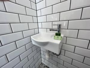a white sink in a white tiled bathroom at Flat 14, 10 St John’s in Bournemouth
