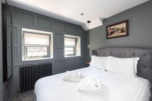a bedroom with a large white bed with two towels on it at Luxury Castle View 3 Bedroom 2 Bathroom Apartment in Edinburgh