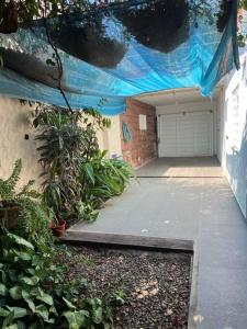 a garage with a blue tarp over a driveway at Alquiler de casa zona Cerro in Córdoba