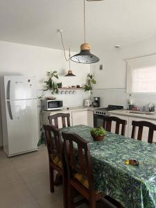 a kitchen with a table and a white refrigerator at Alquiler de casa zona Cerro in Cordoba