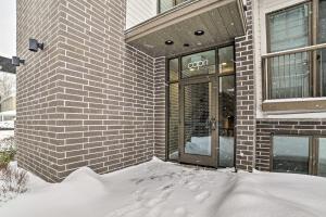 a building with snow on the ground in front of a door at Traverse City Condo - Half-Mile to Front Street in Traverse City