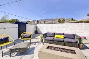 une terrasse avec un canapé, des chaises et une cheminée dans l'établissement Stylish Palm Springs Home with Outdoor Oasis!, à Palm Springs