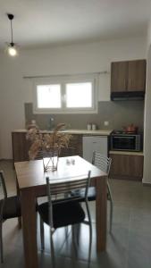 a kitchen with a wooden table and chairs in a room at Calm Rooms in Agioi Apostoli +14 photos
