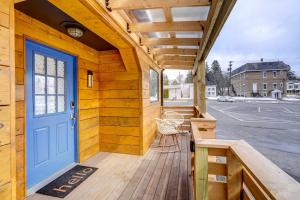 a porch with a blue door on a wooden house at Pet-Friendly Dryden Vacation Rental! 