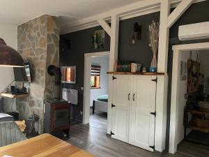 a living room with a white cabinet and a stove at Haus Brunhilde in Plodda