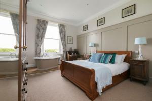 een slaapkamer met een bed en een bad en een bad bij Mount Ephraim B&B in Hernehill