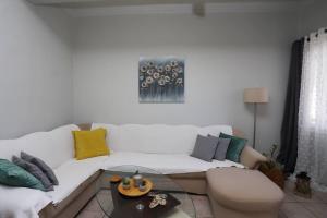 sala de estar con sofá blanco y almohadas coloridas en “Katerina’s Guest House”, en Káto Garoúna