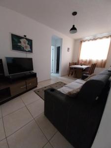 a living room with a couch and a television at AGUA MAIS in Campos dos Goytacazes +8 photos